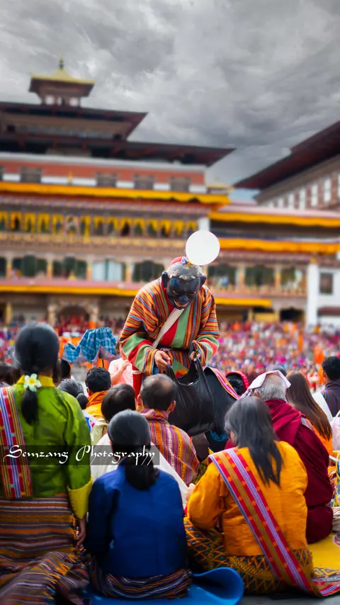 Spectators seated in the dzong courtyard beneath the tower