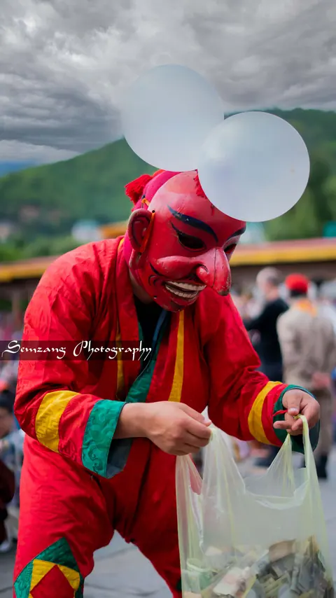 Atsara clown in a red mask and robes at the festival