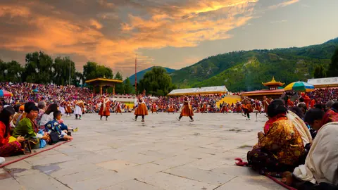 Sunset over the festival ground with dancers and seated spectators