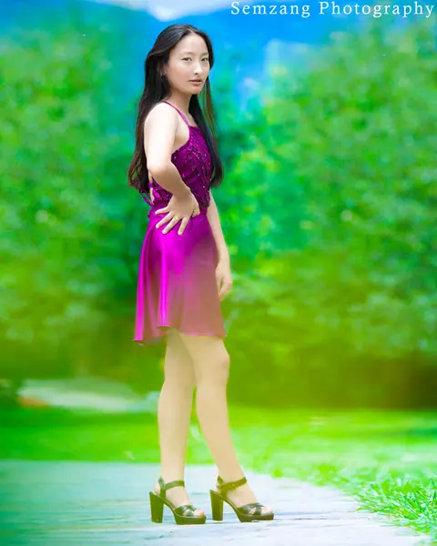 Woman in a purple dress walking along a green path