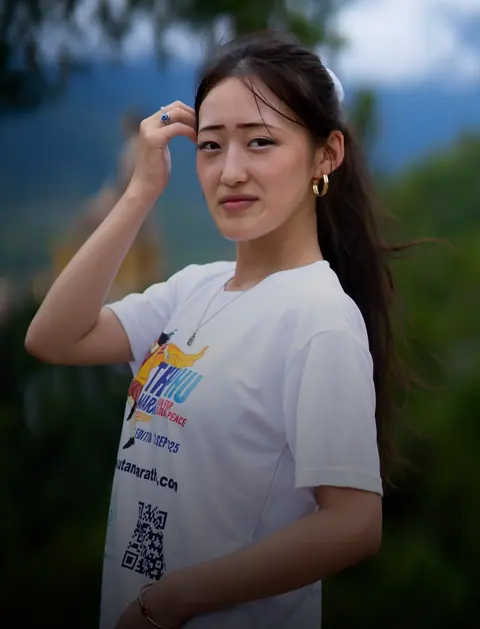 Young woman with long hair in a white t-shirt outdoors