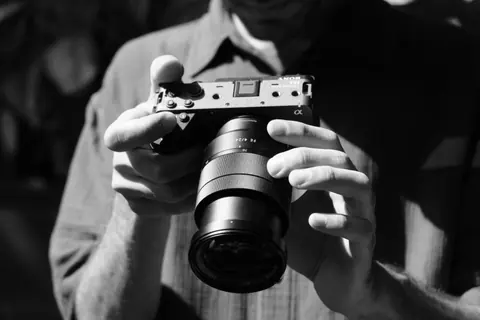Black and white photo of hands holding a film camera